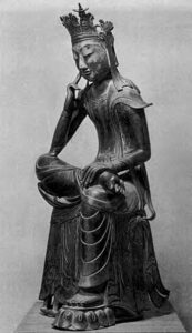 statue of a man sitting, one foot crossed over the other leg, with his hand in a thoughtful position