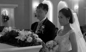 photo of a man and woman in wedding garb at an altar