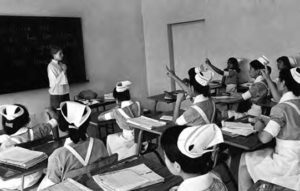 a woman stands in the front of the class and teaches a group of women