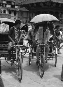 men on bikes with carriages on the back and umbrella 