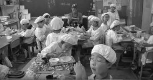 The classroom desks are arranged for lunch by the children to seat groups of four to six.