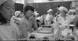 young students brushing their teeth