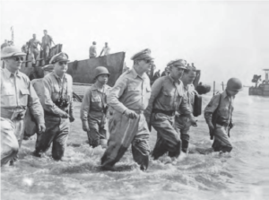 General Douglas MacArthur along with military men wades ashore during initial landings at Leyte, Philippine Islands. 