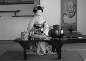 a photo of a woman in kimono pouring tea