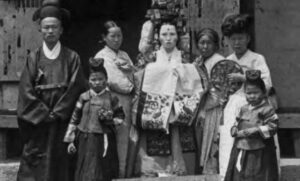 photo of a painted bride with other people around her, all wearing elaborate robes