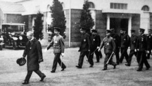 A group of military/ political men walk together. 