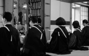 Six individuals sit on a tatami mat.