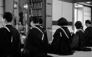 Six individuals sit on a tatami mat. 