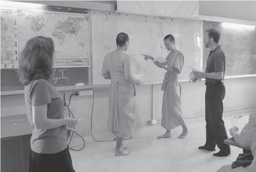 photo of four people working at a whiteboard