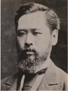 A photograph of Mori Arinori captured from the head to the shoulders. He appears to be a middle-aged individual with a long beard. His gaze is focused and intense as he stares directly at the photographer.