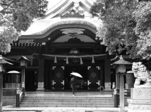 a photo of a person with an umbrella walking up to a shrine