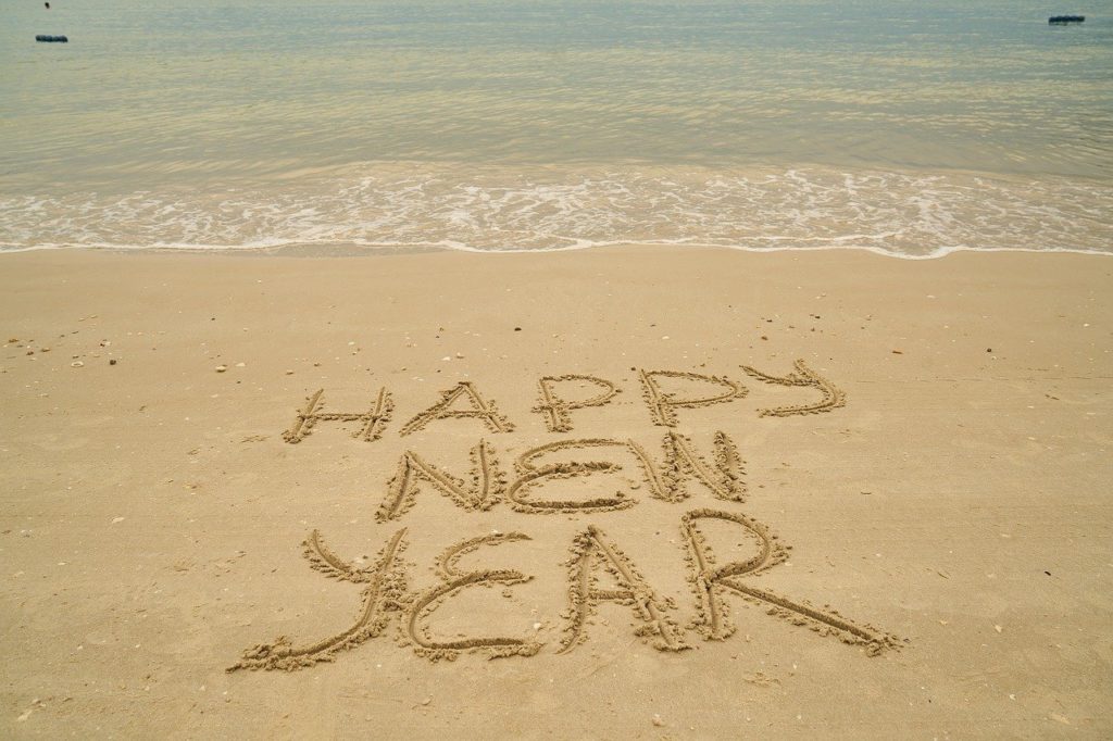 Image of "Happy New Year" written in the sand