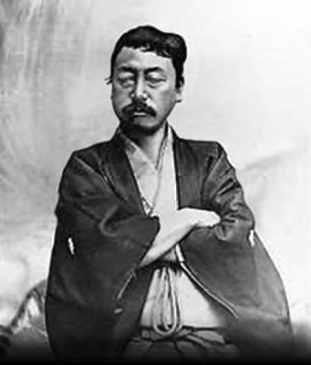 Okakura Tenshin as a middle aged man with a full head of hair and a short mustache. He is wearing a kimono. 