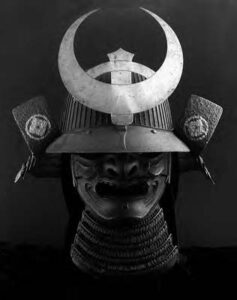 a photograph of a helmet, with flaps on the side and a giant crescent moon on the front
