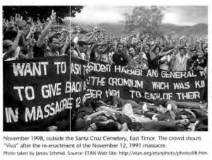 a large amount of people hold a banner calling for justice after a massacre