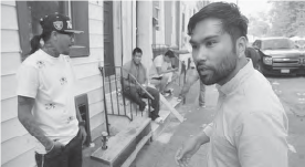 Image shows a man talking to a young men in the street