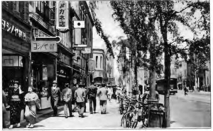 photo of people walking down a sidewalk near shops