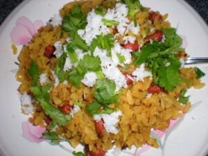 photo of a bowl of poha with greens in it