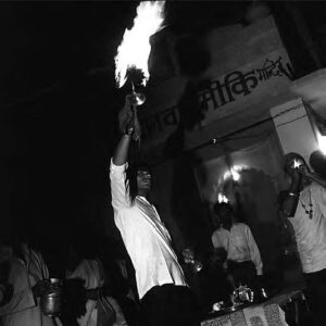 a man holds up a flaming candelabra