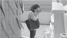 Image of a woman praying at her family stupa