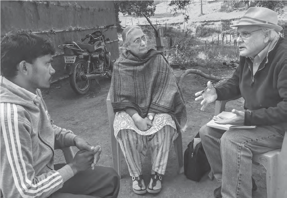 Image of a Western man speaking with a man and woman in village