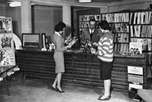 a photo of women standing in a record shop holding records