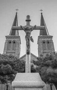 a statue of christ on the cross in front of a church