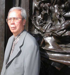 photo of a man in front of a relief sculpture