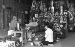 Two worshippers conduct offerings at a shrine in Wat Doi Suthep.