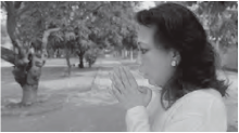 Screenshot of a woman with praying pose