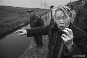 Image of an angry woman pointing at the river and talking 