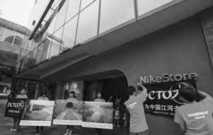 Image of two people hang the Nike Store sign on the wall