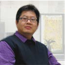 Face portrait of Shei-Chau Wang. He is wearing a purple shirt, navy vest, and glasses. 