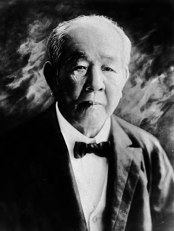 Portrait of Viscount Shibusawa Eiich as an old man. He is staring sternly at the camera and has white balding hair. He is wearing a Western style business suit. 