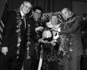 Photo shows four people holding a award with smile