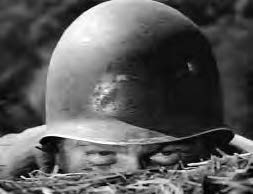 a man peeks out, with only his helmet and eyes exposed