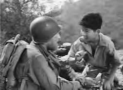 a boy speaks to a man in uniform