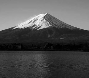 a snow capped mountain with a lake in front of it.