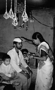 a man sits with his eyes closed as a woman touches his forehead