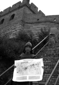 photo of a man standing in a military uniform (armor) in front of a section of the great wall