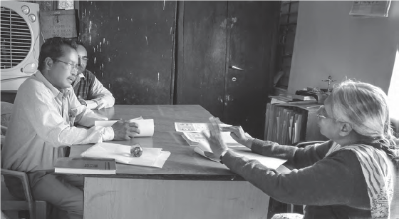 Picture of a woman and two men talking in the office