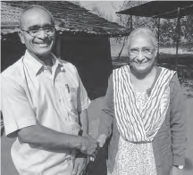 Picture of a man smiling and shaking hands with a woman