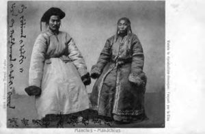 A black and white photograph of man and a woman seated next to each other, wearing fur lined robes.