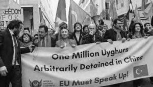 photo of a large group of protestors holding a banner that reads one million uyghurs arbitrarily detained in china