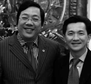 photo of two men in suits smiling 