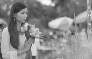 photo of a woman praying with lotus flower buds in her hands